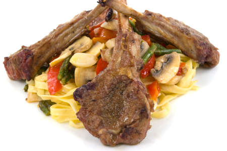 Lamb chops, homemade pasta with tomatoes, asparagus, red and orange bell peppers, mushroom, shallots, and garlicの写真素材
