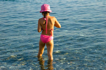 A little girl playing with water at the beachの写真素材