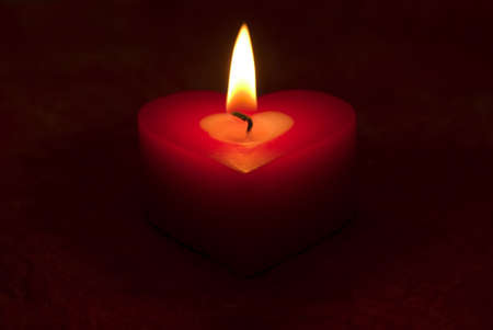 Romantic heart shaped candle and candlelightの写真素材