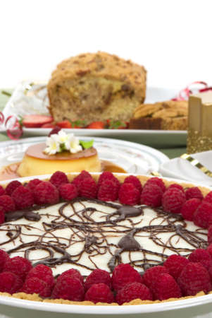 Elegant table with many desserts and fruits ( pecan swirl cake, raspberry pie, creme caramel, and more)の写真素材