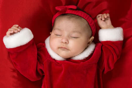 3 month old baby sleeping with her Christmas dressの写真素材