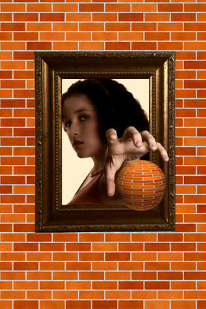 Girl reaching to a brick ball ( brick wall rendered digitally)の写真素材