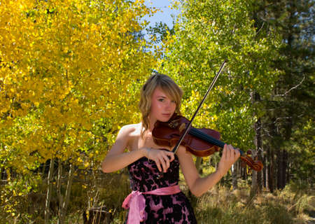 Girl playing violin with a lace designer dress の写真素材