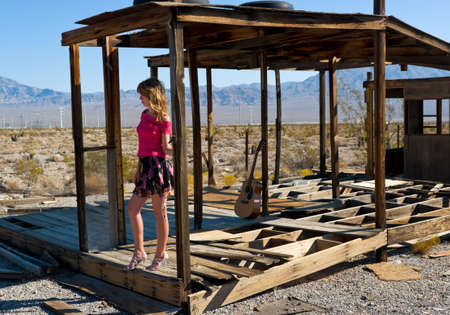 Fashion model and an abandoned house in Nevada desert.