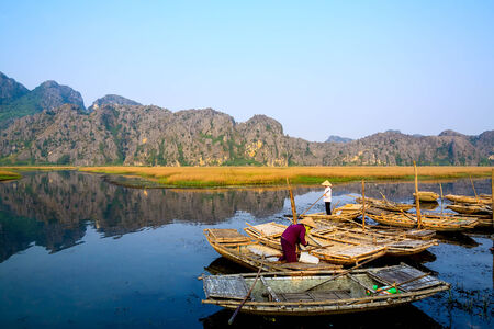 HANOI, VIETNAM - NOVEMBER 2, 2014  girl in traditional costume rowing boat in the flooded forest in MYDUC, VIETNAMのeditorial素材