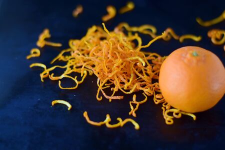 Fresh mandarine zest with full fruits on a dark blue abstract background. Selective focus.の写真素材
