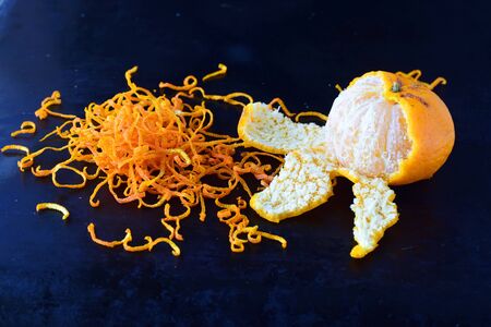 Fresh mandarine zest with full fruits on a dark blue abstract background. Selective focus.の写真素材