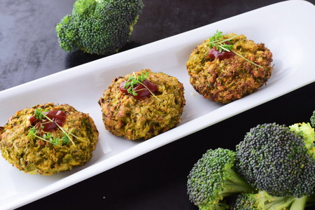 Broccoli balls deep fried on a white plate with tomato sauce with fresh broccoli on a black abstract background. Healthy eating concept. Dietingの写真素材