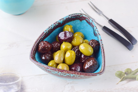 Green and black olives in olive oil in a traditional Greek bowl. Mediterranean lifestyleの写真素材