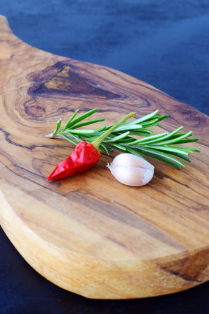 Herbs and spices on a wooden cutting board on a black abstract backgroundの写真素材