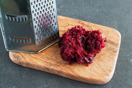 Grated boiled beetroot on an olive wood cutting board. Step by step cookingの写真素材