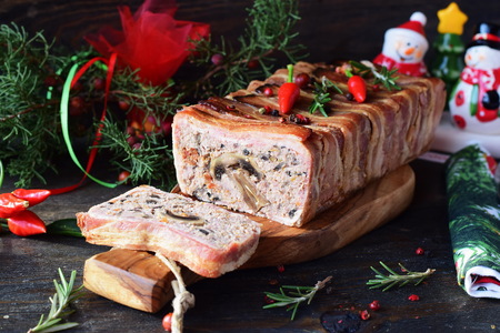 Oven baked meatloaf with mushrooms wrapped in bacon on a concrete grey background.の写真素材