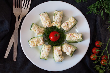 Appetizer from a fresh cucumber with crab meat, egg, cheese and dill. Christmas and New year coceptの写真素材
