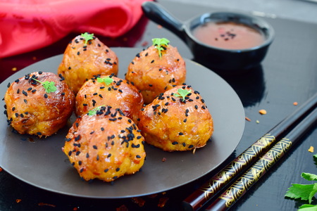 Spicy chicken balls in sweet chilli glaze on a metal trayの写真素材