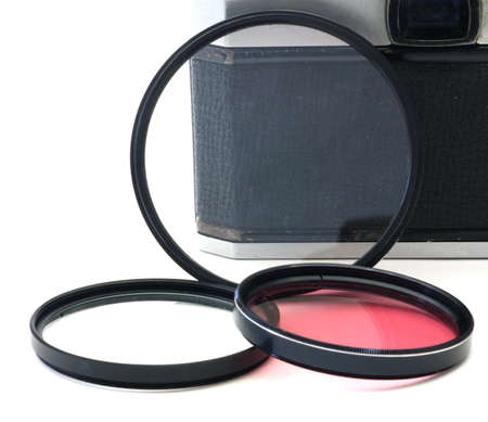 Three photography filters next to a vintage 35mm camera. の写真素材