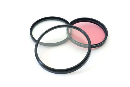 Three round camera filters with clear and rose colored glass. の写真素材
