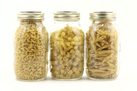 Assorted pasta in three clear glass jars. の写真素材