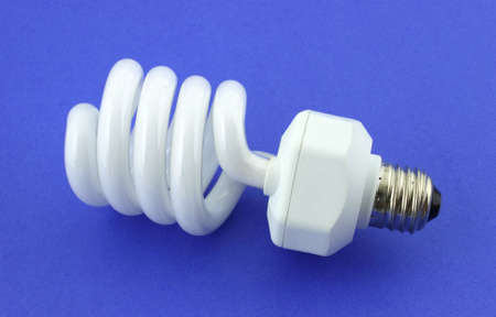 A compact fluorescent light bulb against a blue background. の写真素材
