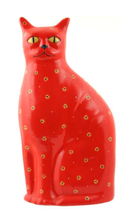 A very brightly colored red ceramic cat with yellow eyes and flowers.の写真素材