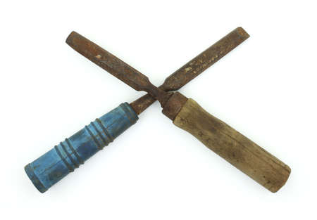 Two antique chisels with a blue and tan handle crossed against a white background.の写真素材