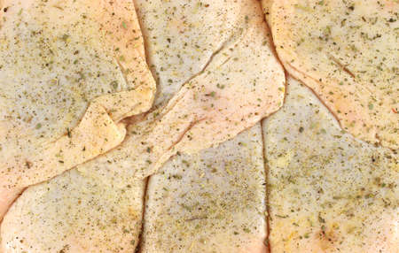 A close view of several chicken thighs that have been seasoned for cooking. の写真素材