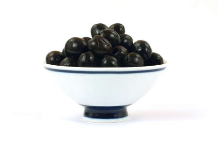 Black pitted olives in a white bowl の写真素材