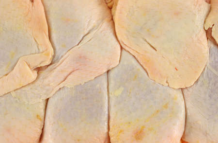 A close view of several chicken thighs ready to be seasoned and cooked. の写真素材