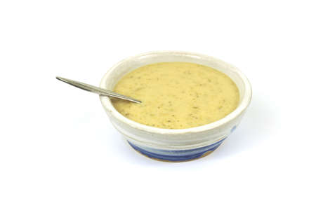 Cream of broccoli soup in bowl with spoonの写真素材