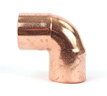 A small ninety degree copper pipe fitting on a white background. の写真素材