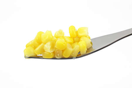 A single fork filled with corn on a white background.の写真素材