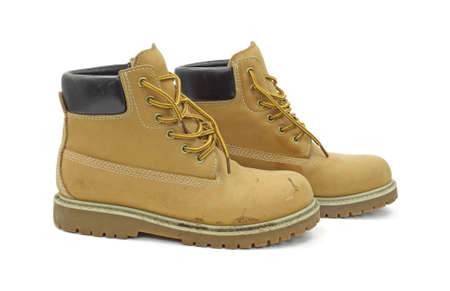 A pair of worn work boots on a white background.の写真素材