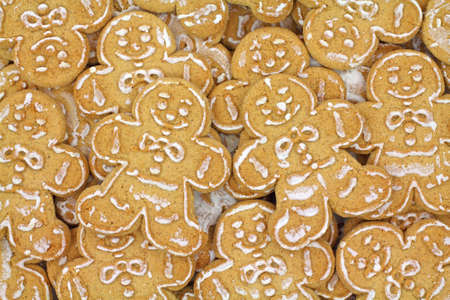A very close view of several layers of iced gingerbread cookies.