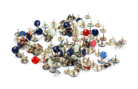 Several multiple color thumbtacks scattered on a white background. 