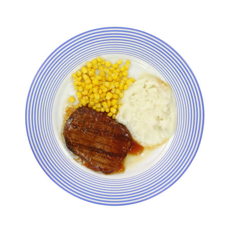 Salisbury steak meal with corn and potato on a blue striped plate.の写真素材
