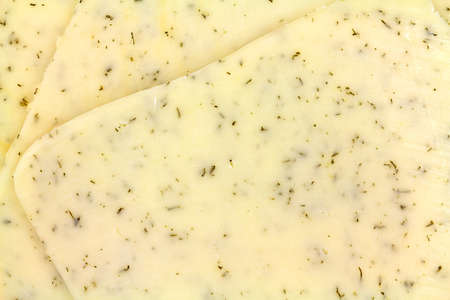 Close view of several slices of havarti cheese with dill seasoning.の写真素材