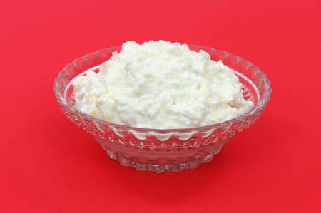 Cottage cheese with pineapple in a small glass dish on a red background. の写真素材