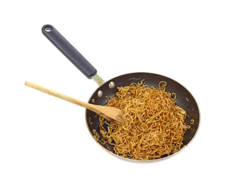 Cooked chow mein noodles that have been seasoned in an old black skillet on a white background.の写真素材