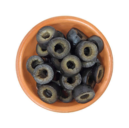 A small bowl filled with sliced black olives on a white background.の写真素材