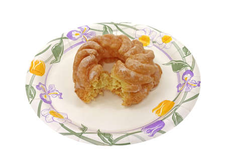 A bitten cruller on a floral design paper plate.
