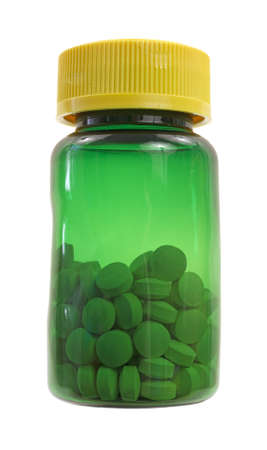 A green vitamin bottle half full of iron tablets on a white background. の写真素材