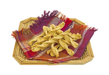 Several garlic and parmesan cheese bread sticks in wicker basket and napkin on a white background.