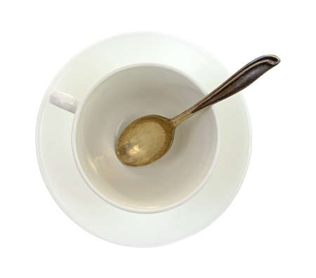 An empty white cup and saucer with silver spoon.
