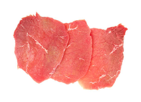 Three thin slices of fresh beef eye round steak on a white background. 