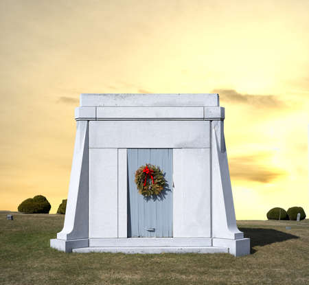 A stone mausoleum with an old wreath on door with yellow sky の写真素材