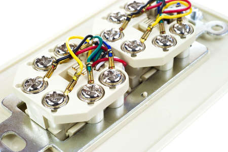 A close view of the wires on the back of a dual telephone outlet 