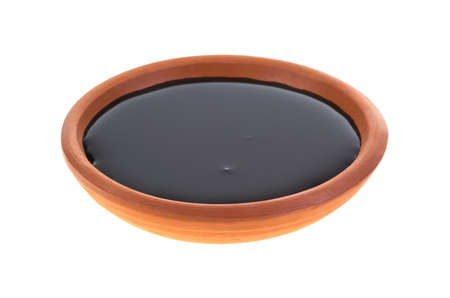 A small dish with molasses on a white background の写真素材