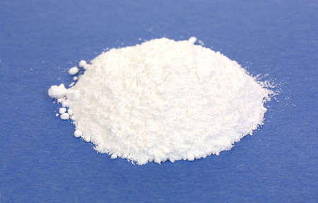 A small portion of calcium citrate powder on a blue background 