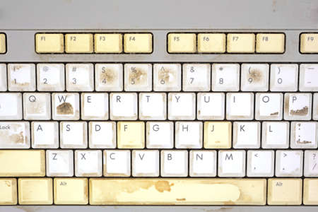 A close view of some keys on a dirty, yellowed keyboard の写真素材