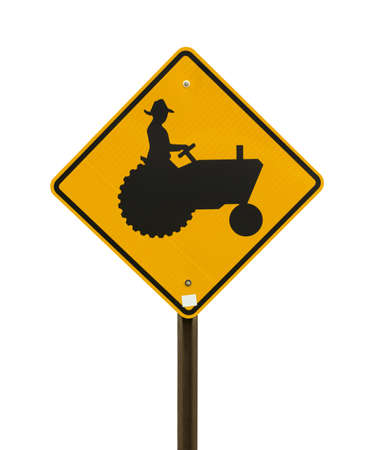 A bright yellow farm tractor sign on a white background の写真素材