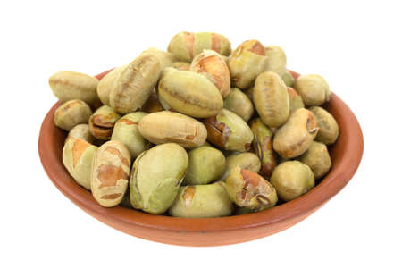 A small clay bowl filled with edamame soybeans on a white background の写真素材